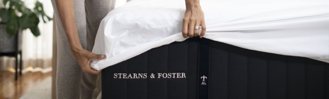 Woman putting sheets on a Stearns & Foster® mattress